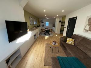 a living room with a couch and a flat screen tv at Apartman Old Corner in Virovitica