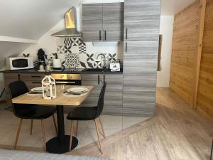 a kitchen with a table and chairs in a room at Studio Chalet Centre in Gérardmer
