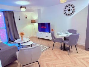 Best Area Stylish1Bed, Games, Relax, Parking في برمنغهام: غرفة معيشة مع طاولة وكراسي وتلفزيون