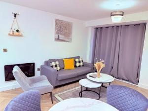 Best Area Stylish1Bed, Games, Relax, Parking في برمنغهام: غرفة معيشة مع أريكة أرجوانية وكراسي