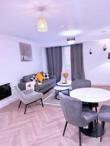 Best Area Stylish1Bed, Games, Relax, Parking في برمنغهام: غرفة معيشة مع أريكة وطاولة وكراسي
