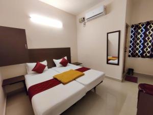 a bedroom with a large white bed with red pillows at Super Hotel O Red Moon Residency in Chennai +1 photo