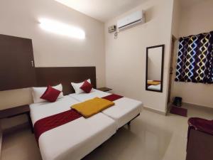 a bedroom with a large white bed with red pillows at Super Hotel O Red Moon Residency in Chennai