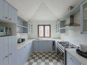 Casapueblo Rent Cachagua CP 35 في Cachagua: مطبخ بخزائن بيضاء وأرضية مربعة