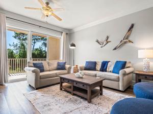 a living room with two couches and a table at Sanctuary at Redfish 1106 by Newman-Dailey in Blue Mountain Beach
