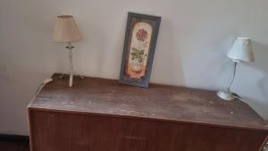 un quadro sopra una cassettiera con due lampade di Mansión CA a Barraquero