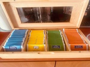 Un cajón de madera lleno de cajas de pasta de diferentes colores. en Korali Hotel, en Paralia Katerinis