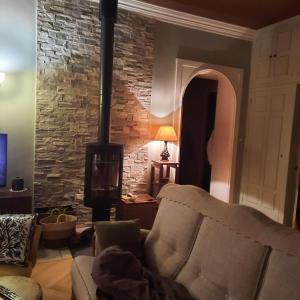 Chez Sylvie في سان فوي لي ليون: غرفة معيشة مع أريكة وجدار من الطوب +15 صورة