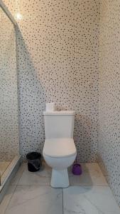 a bathroom with a toilet in a tiled wall at Paradise Búzios in Búzios