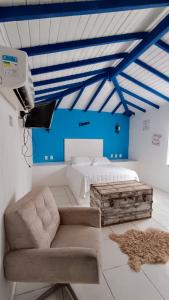 a bedroom with a bed and a couch and a tv at Paradise Búzios in Búzios