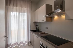 - une cuisine avec une fenêtre, un évier et un comptoir dans l'établissement Varicottis Luxury Apartments con parcheggio privato, à Varigotti