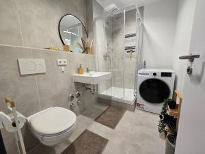 a bathroom with a toilet and a shower and a sink at Große Wohnung mit Balkon nahe München in Ismaning +45 photos