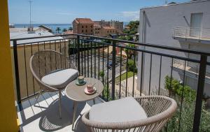 un balcon avec deux chaises et une table sur un balcon dans l'établissement Varicottis Luxury Apartments con parcheggio privato, à Varigotti