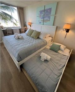 un grande letto con due cuscini sopra in una camera da letto di Beautiful Honolulu Waikiki Ocean View Condo a Honolulu