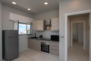 une cuisine avec des armoires blanches et un four à plaques de cuisson dans l'établissement Varicottis Luxury Apartments con parcheggio privato, à Varigotti