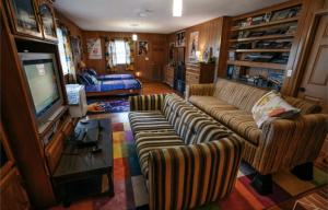 a living room with a couch and a television at 1980's Themed Room with MASSIVE 80's Arcade in Winston-Salem