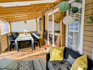eine abgeschirmte Veranda mit einem Tisch und Stühlen in der Unterkunft Mobil home Apollon Riviera in Saint-Papoul
