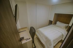 a small room with a bed and a table at Torre U kooliving in Manizales