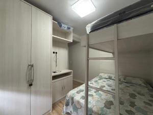 ein Schlafzimmer mit einem Etagenbett und ein Badezimmer in der Unterkunft Ap Pertinho do Mar! in Balneário Camboriú