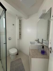 ein weißes Badezimmer mit Toilette und Waschbecken in der Unterkunft Ap Pertinho do Mar! in Balneário Camboriú
