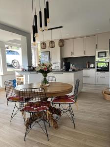 una cucina con tavolo e sedie in legno e tavolo e una cucina di Maison Cosy et Moderne a Vila Real