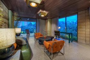 a living room with orange furniture and a large window at 23 Living in Medellín