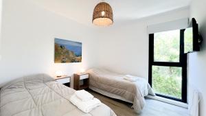 a bedroom with two beds and a window at Casa Altamar - Casa Con Vista Al Mar en Playa Cruz del Sur, Chapadmalal Para 6 PAX Con Parrilla y Cochera - Hola Sur in Chapadmalal