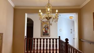 a staircase with a chandelier in a house at Hotel Vitoria Marchi in Serra Negra