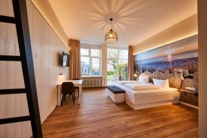 Wangerland Resort في انجرلاند: غرفة نوم بسرير ابيض ومكتب +81 صورة