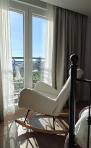 Orion Palace Boutique Hotel في دوريس: كرسي جلوس امام نافذة مطلة