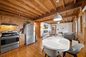 una cucina e una sala da pranzo con tavolo e sedie bianchi di Fox Trail Cabin a New River Heights
