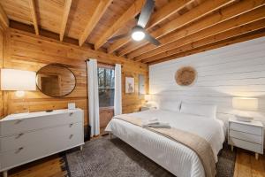 una camera da letto con un letto bianco e un soffitto in legno di Fox Trail Cabin a New River Heights