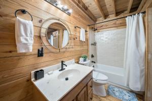 un bagno con lavandino, WC e specchio di Fox Trail Cabin a New River Heights Altre 13 foto