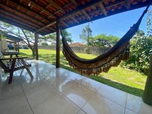 a hammock in a porch with a view of a yard at Morada Carmem in Praia do Rosa