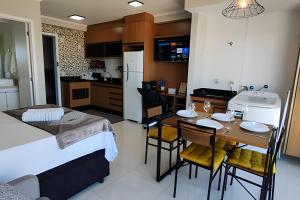 a room with a kitchen and a table with chairs at Aeroporto Gru, Ar Condicionado, Piscina+Academia in Vila Gopoúva