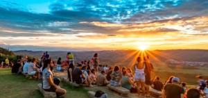 a crowd of people sitting on a hill watching the sunset at Tiny House Socorro in Socorro