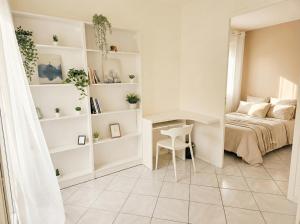 una piccola camera da letto con un letto e una scrivania di Le Sky - Penthouse de Standing Hyper-Centre Orsay Paris Saclay a Orsay