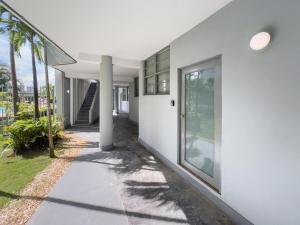 um corredor de uma casa branca com palmeiras em La Rada 015 Studio Apt in San Juan with Pool em San Juan