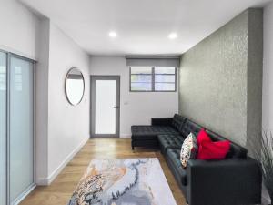 una sala de estar con un sofá negro y una pared en La Rada 015 Studio Apt in San Juan with Pool, en San Juan 15 fotos más