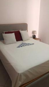 a large bed with white sheets and pillows on it at Condominio atlantico ll in Praia +12 photos