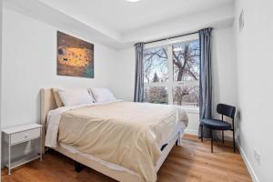a white bedroom with a bed and a window at Luxurious Large 3 Bedroom Loft Saskatchewan Drive in Edmonton