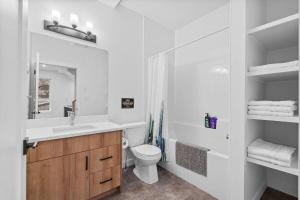 a white bathroom with a sink and a toilet at Luxurious Large 3 Bedroom Loft Saskatchewan Drive in Edmonton +20 photos