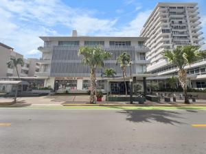 um grande edifício com palmeiras em frente a uma rua em La Rada 015 Studio Apt in San Juan with Pool em San Juan