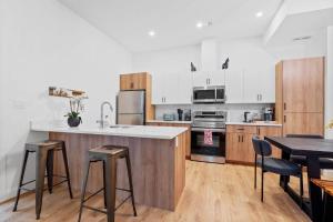 a kitchen with white cabinets and a table and chairs at Luxurious Large 3 Bedroom Loft Saskatchewan Drive in Edmonton