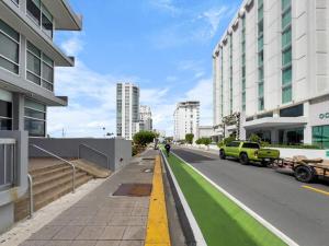 una calle de la ciudad con aceras verdes y edificios en La Rada 015 Studio Apt in San Juan with Pool, en San Juan