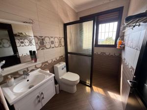 a bathroom with a toilet and a sink at Ariette Homes in Buwate