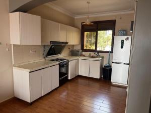 a kitchen with white cabinets and a white refrigerator at Ariette Homes in Buwate +8 photos