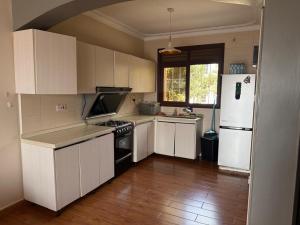 a kitchen with white cabinets and a white refrigerator at Ariette Homes in Buwate