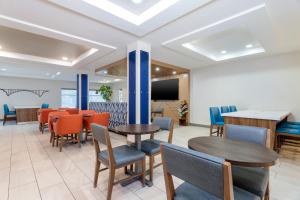 a waiting room with tables and chairs and a tv at Holiday Inn Express Hotel Twin Falls by IHG in Twin Falls