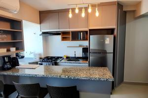 a kitchen with a refrigerator and a counter top at Aeroporto Gru, Ar Condicionado, Piscina+Academia 7 in Guarulhos